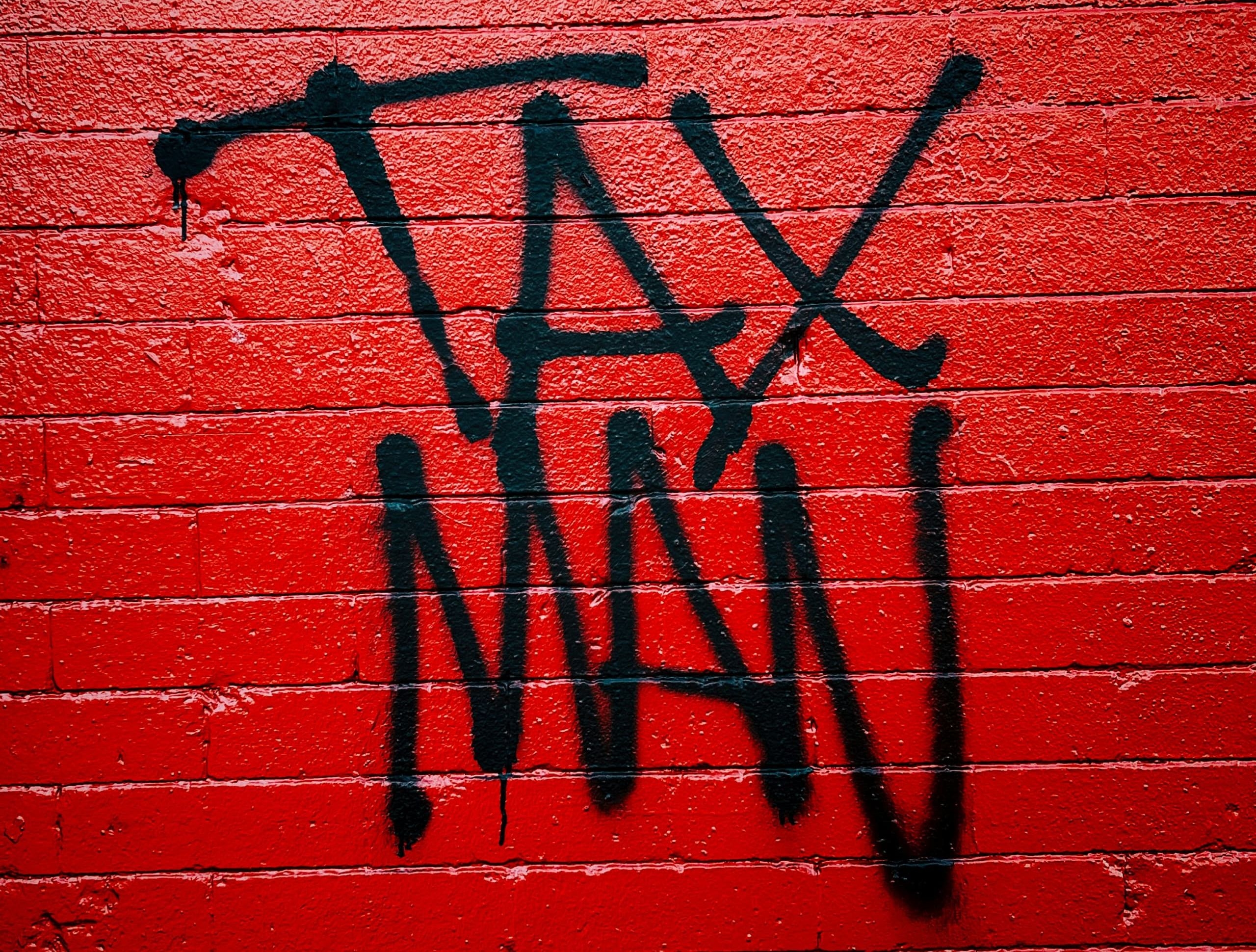 Wall with graffiti with the text "Tax Man"